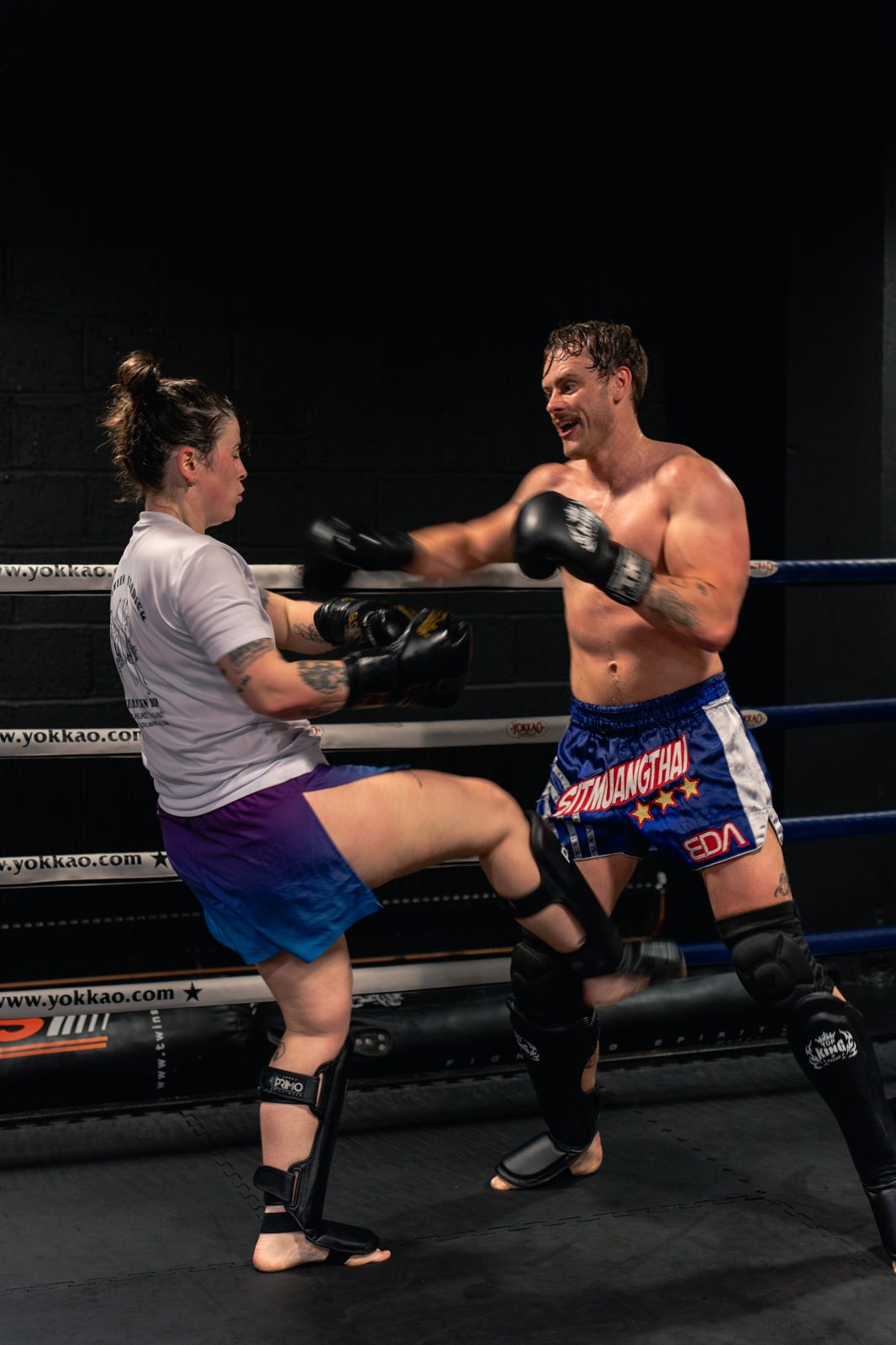 Members sparring in the ring during a Muay Thai session
